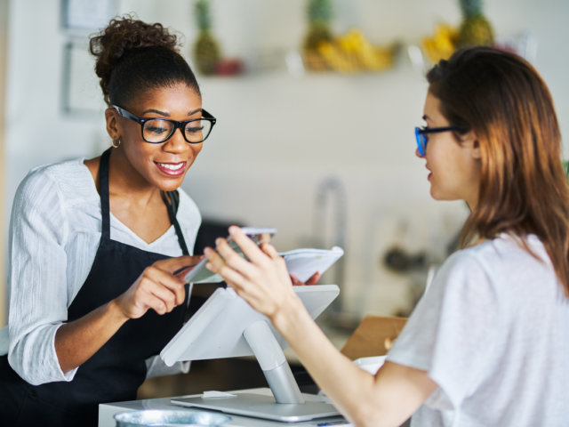 customer using online coupon from smartphone app at restaurant