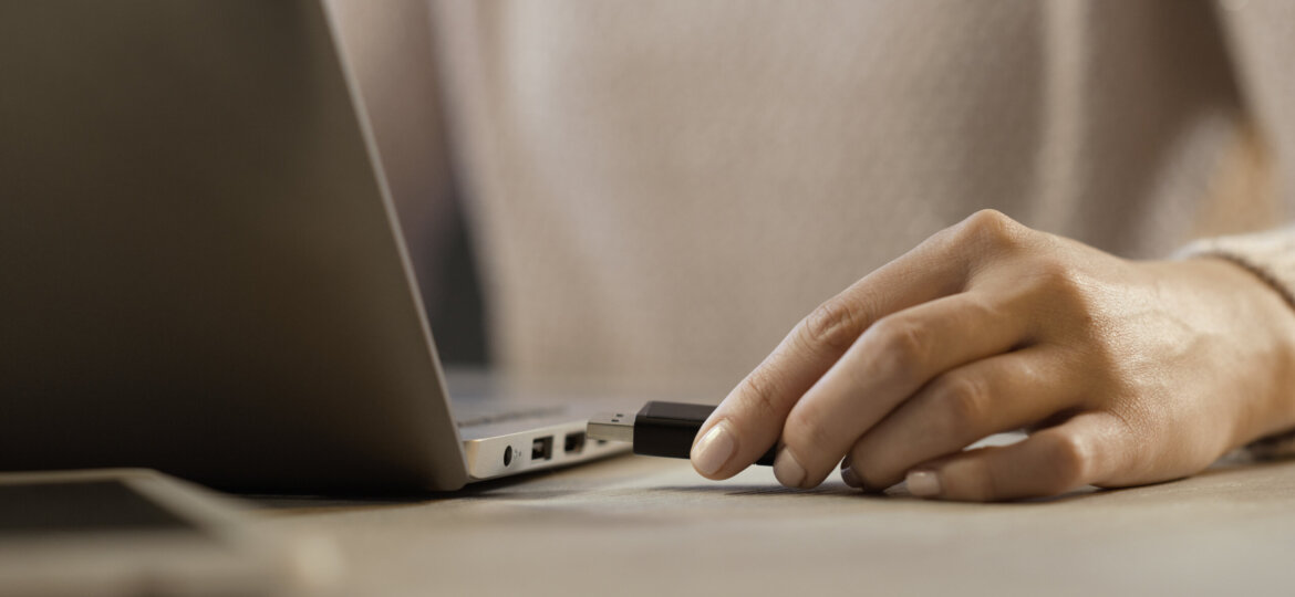 Woman plugging a USB flash drive into her laptop